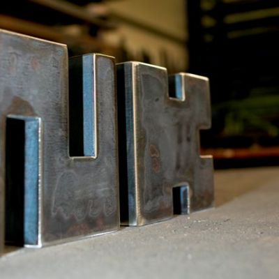 Stahlbearbeitung:
<br />

<br />
Wort-Architektur-Teile (Buchstaben) 
<br />
nach Grob-Schleifen